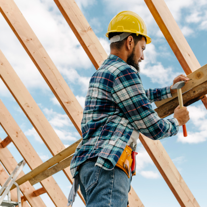 MAN WORKING ON A ROOF ON FRAMING